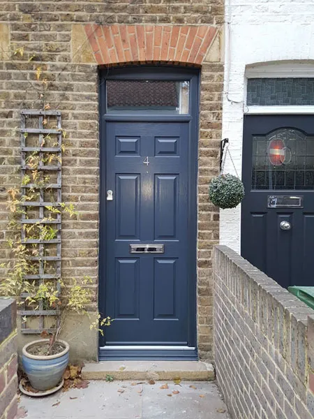 A blue front door on a brick building.