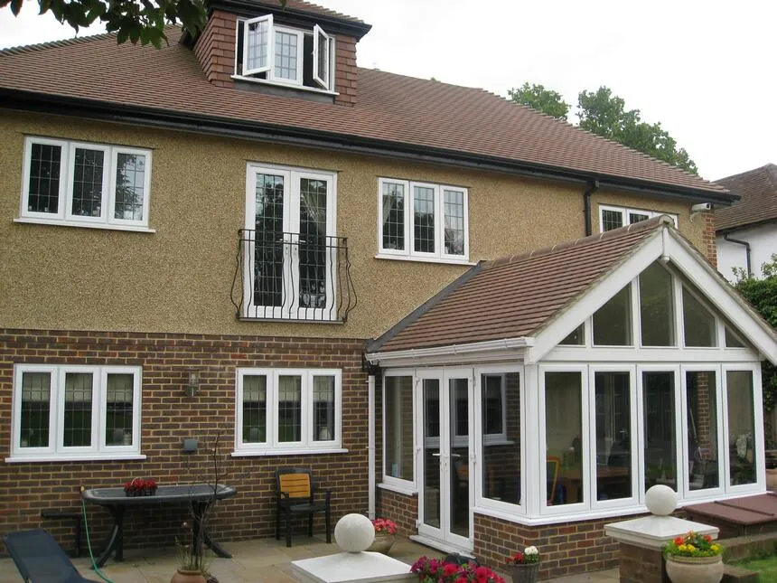 A large house with a patio and a table in front of it.