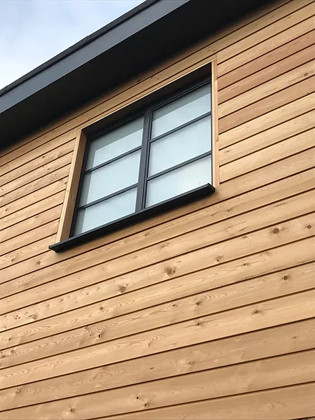 A close up of a wooden building with a window.