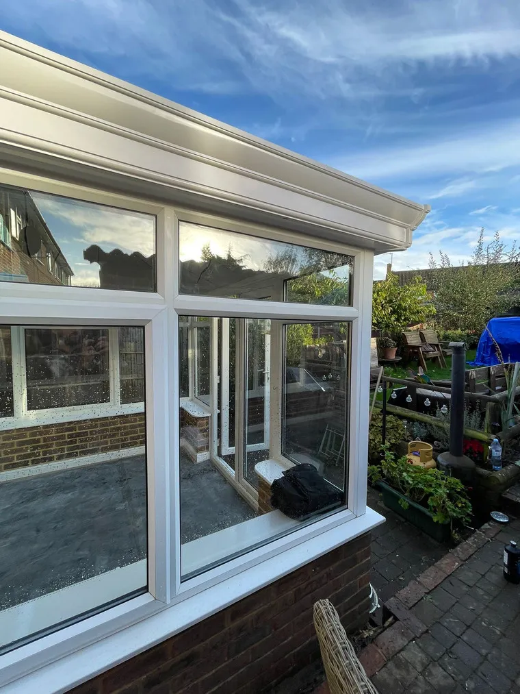 A house with large windows and a blue tarp.
