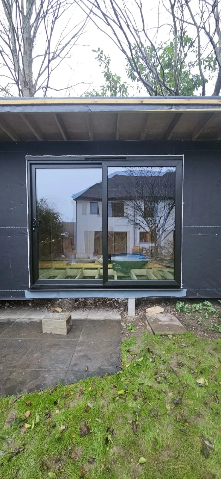 A black building with a large glass window.